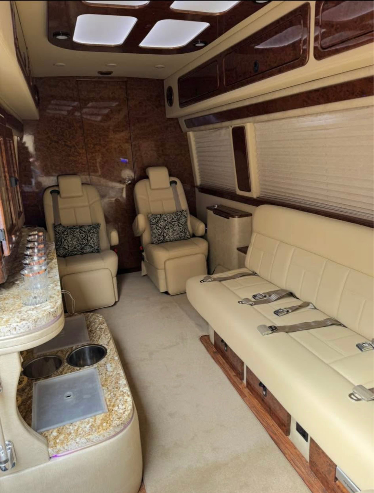 Luxurious limousine interior featuring plush beige leather seats, spacious seating area, and modern amenities for premium transportation services. Perfect for special events and corporate travel.