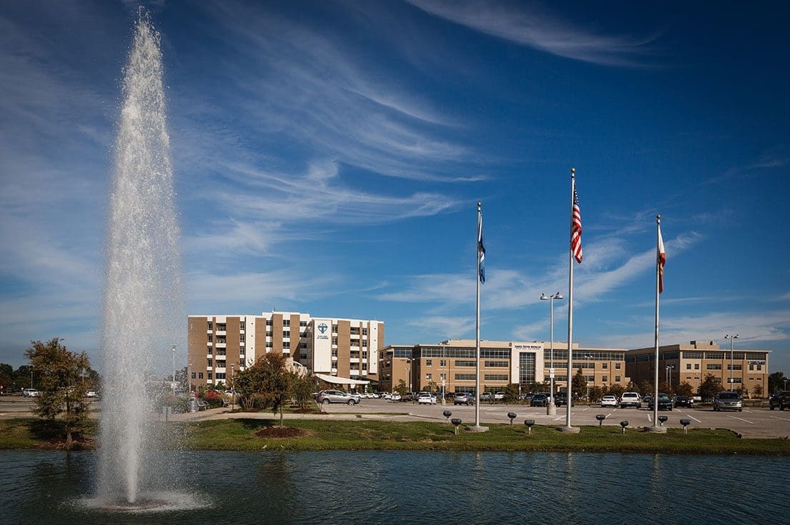 Modern Bayou State Operations facility with flags and water fountain, showcasing professional infrastructure in a corporate setting.