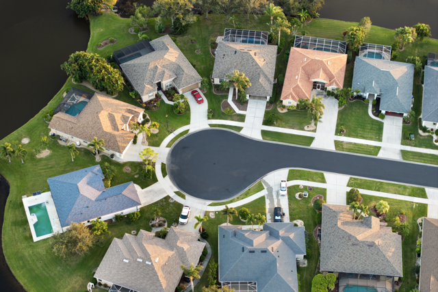 Aerial view of a residential cul-de-sac showcasing attractive houses, manicured lawns, and driveways, emphasizing quality property management and community upkeep.