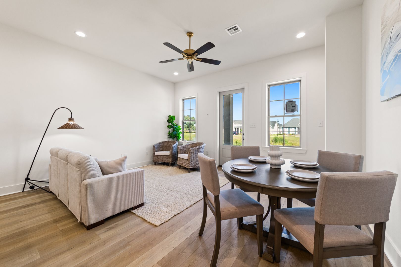 Bright and spacious living and dining room with large windows, neutral decor, and contemporary furniture, perfect for family gatherings and entertaining.
