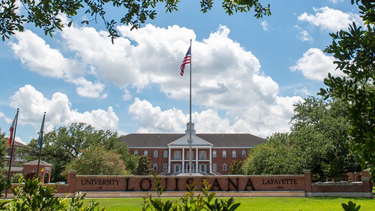 Bright, clear image of Louisiana State University’s historic campus, featuring a prominent flagpole, lush greenery, and brick buildings, emphasizing campus safety, higher education, and university services.